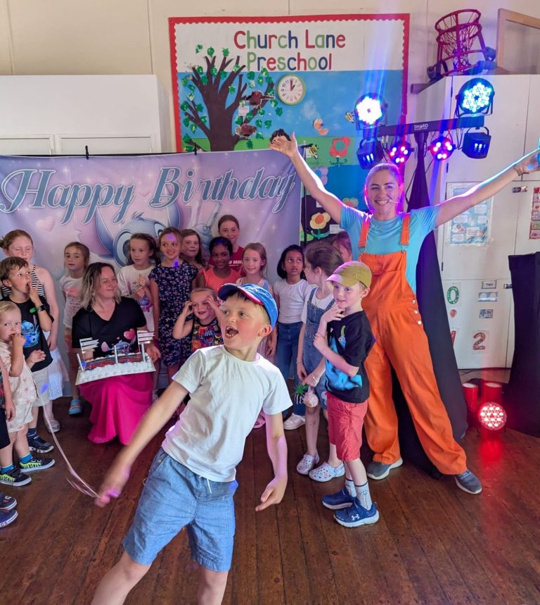 Children enjoying interactive party entertainment in Bath A performer in orange overalls entertains a group of children at a lively event.